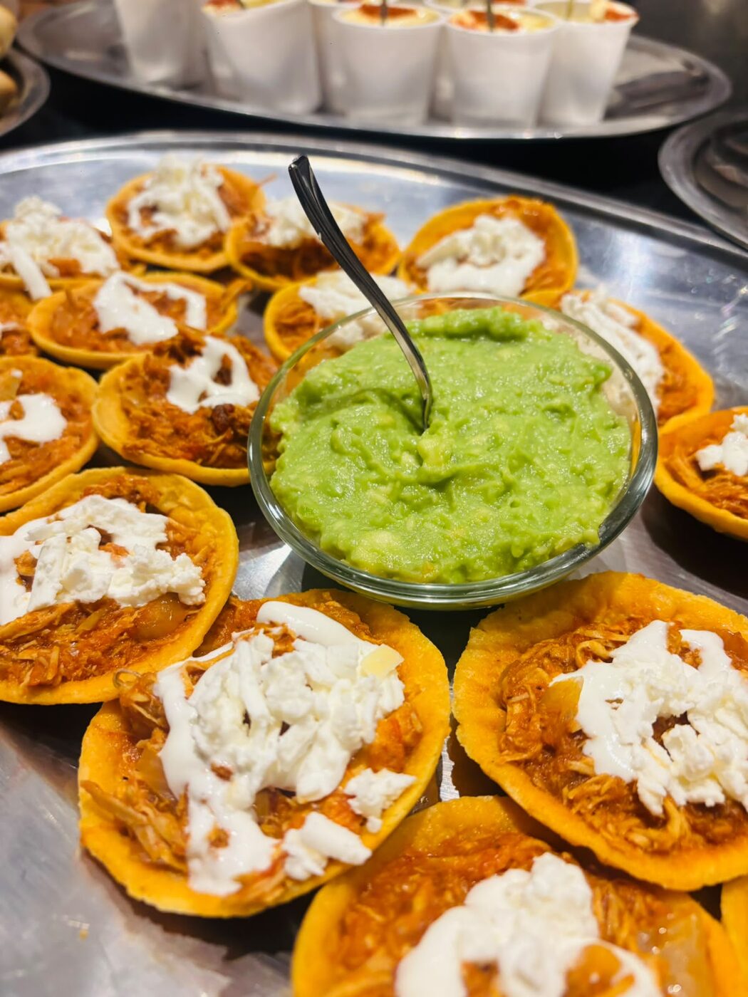 Sopes de tinga con crema y queso acompañados de guacamole en evento de coffee break