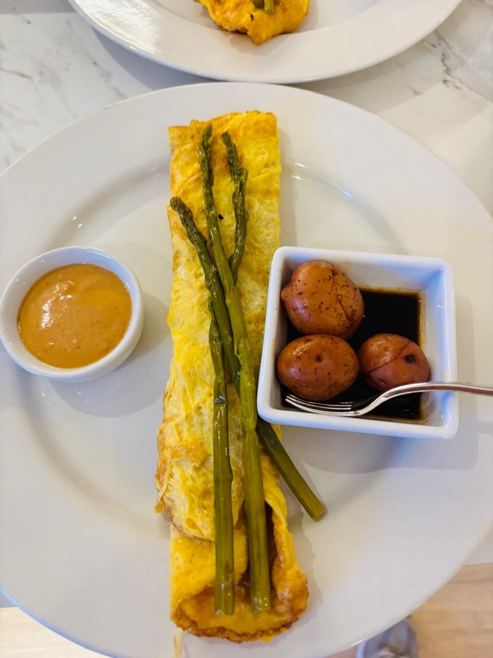 Omelette con espárragos, papas cambray y salsa en desayuno empresarial