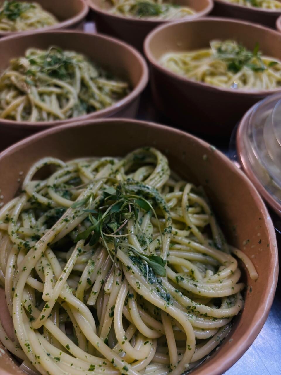 Espagueti al pesto servido en bowls individuales para evento